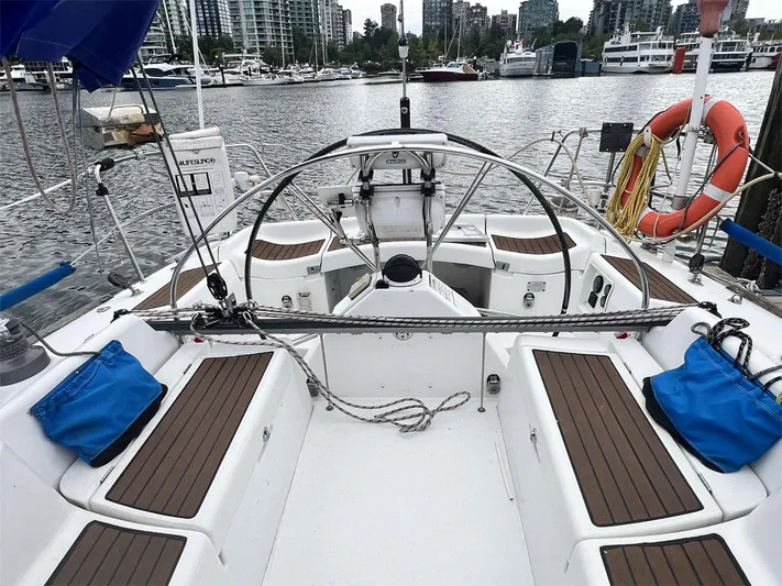Nirvana Yacht Photos Pics Cockpit of 2001 Beneteau First 40.7 sailboat docked in marina, featuring wooden seating.