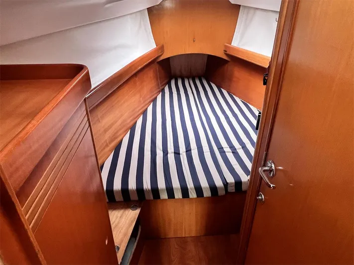 Nirvana Yacht Photos Pics Cabin interior of 2001 Beneteau First 40.7 with striped bedding and wooden finish.
