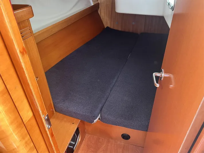 Nirvana Yacht Photos Pics 2001 Beneteau First 40.7 cabin interior with wooden finish and dark cushions.