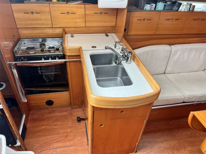 Nirvana Yacht Photos Pics Interior of 2001 Beneteau First 40.7 yacht kitchen with stove, sink, and seating area.