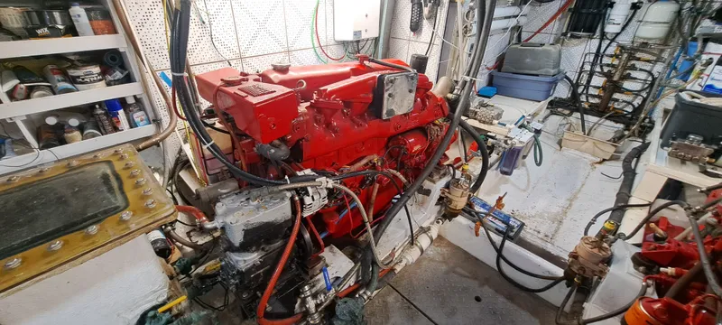 Ballena Blanca Yacht Photos Pics Engine room of 1985 DeFever 44 Trawler with red engine and various equipment.