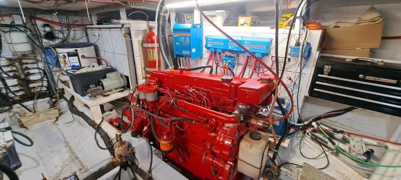 Ballena Blanca Yacht Photos Pics Engine room of a 1985 DeFever 44 Trawler with red machinery and equipment.