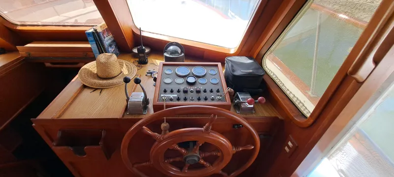 Ballena Blanca Yacht Photos Pics 1985 DeFever 44 Trawler helm with wooden wheel, control panel, and nautical decor.