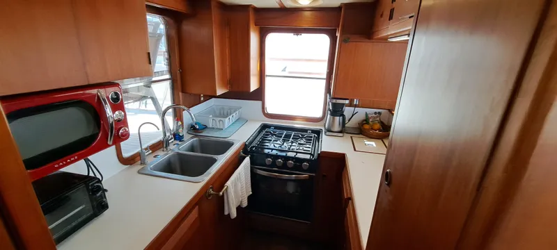 Ballena Blanca Yacht Photos Pics 1985 DeFever 44 Trawler kitchen with stove, sink, and red microwave.