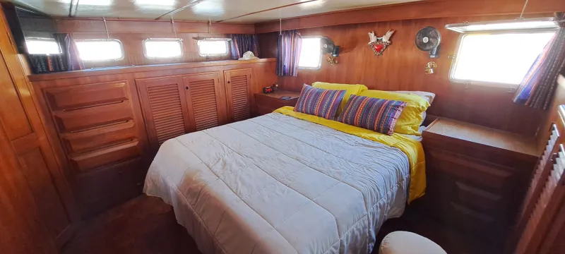 Ballena Blanca Yacht Photos Pics 1985 DeFever 44 Trawler cabin with cozy bed, wooden interior, and natural light.