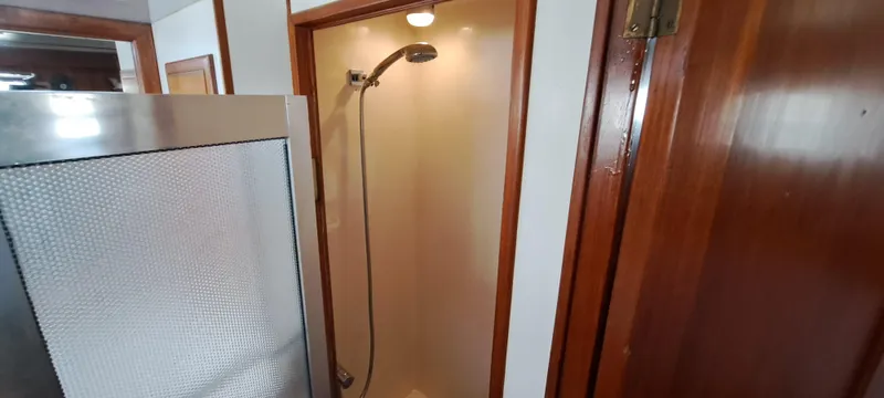 Ballena Blanca Yacht Photos Pics Shower area inside a 1985 DeFever 44 Trawler, featuring wooden trim and modern fixtures.