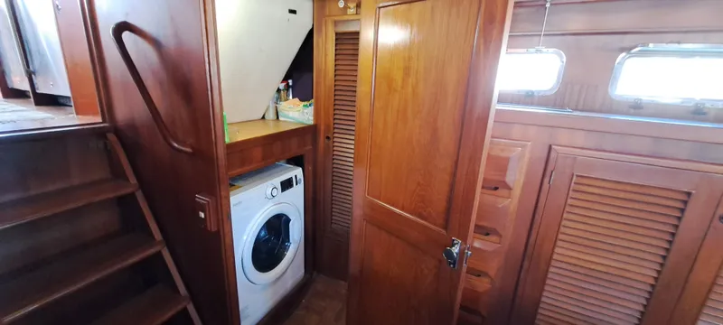 Ballena Blanca Yacht Photos Pics 1985 DeFever 44 Trawler interior with wooden cabinetry and built-in washing machine.