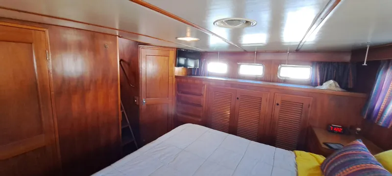 Ballena Blanca Yacht Photos Pics 1985 DeFever 44 Trawler cabin with wood paneling, bed, and storage cabinets.