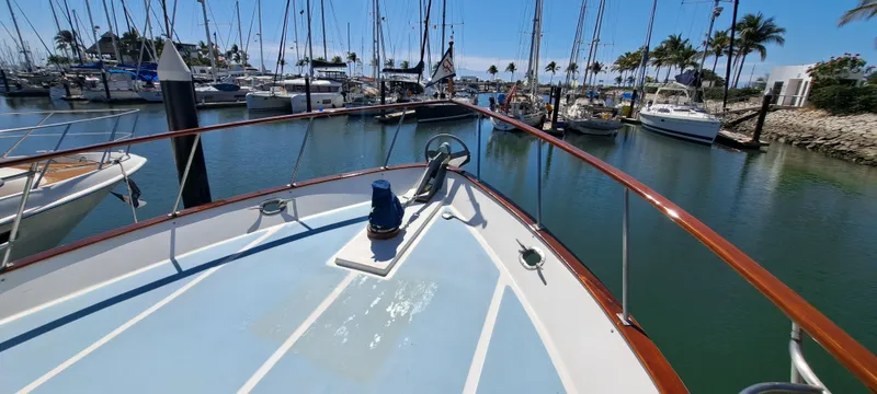 Ballena Blanca Yacht Photos Pics 1985 DeFever 44 Trawler docked in a sunny marina with sailboats.