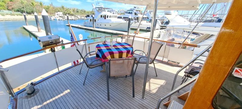 Ballena Blanca Yacht Photos Pics 1985 DeFever 44 Trawler deck with table, chairs, and marina view.