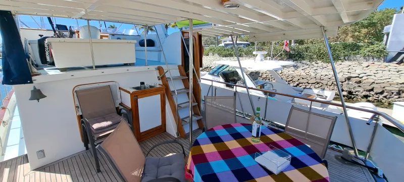 Ballena Blanca Yacht Photos Pics 1985 DeFever 44 Trawler deck with colorful tablecloth, chairs, and outdoor seating area.