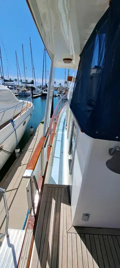 Ballena Blanca Yacht Photos Pics 1985 DeFever 44 Trawler docked at marina, side view with wooden deck.