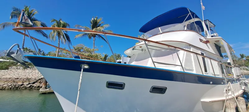 Ballena Blanca Yacht Photos Pics 1985 DeFever 44 Trawler docked, featuring blue accents and tropical palm trees in the background.