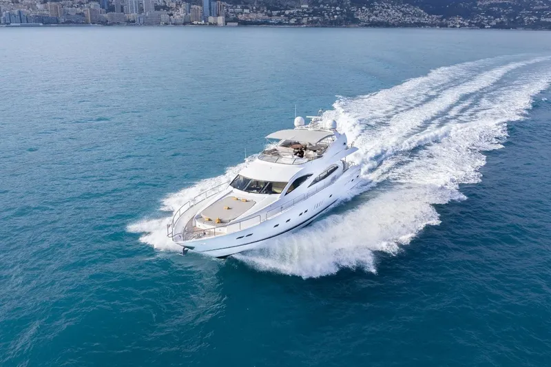 Sunseeker 90 Yacht Yacht Photos Pics Luxurious 2006 Sunseeker 90 Yacht cruising on open water near coastal cityscape.