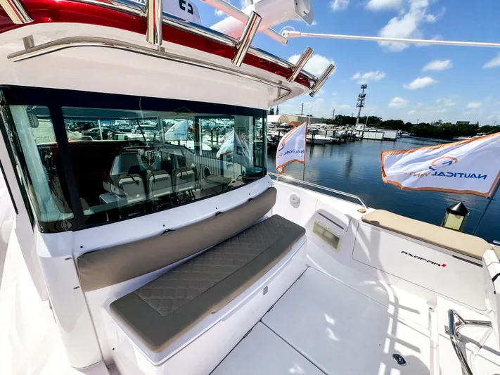  Yacht Photos Pics 2023 Axopar 37 XC CROSS CABIN boat with seating, docked at marina under clear sky.