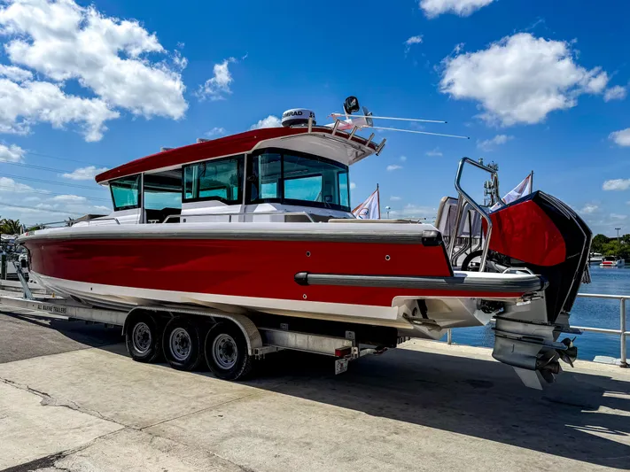  Yacht Photos Pics 2023 Axopar 37 XC CROSS CABIN boat on trailer, red and white design, sunny day.
