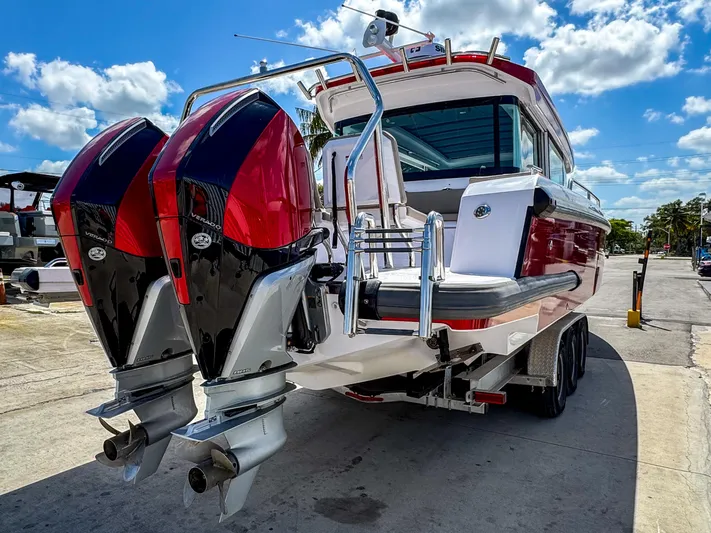  Yacht Photos Pics 2023 Axopar 37 XC CROSS CABIN with dual outboard engines, docked under a sunny sky.