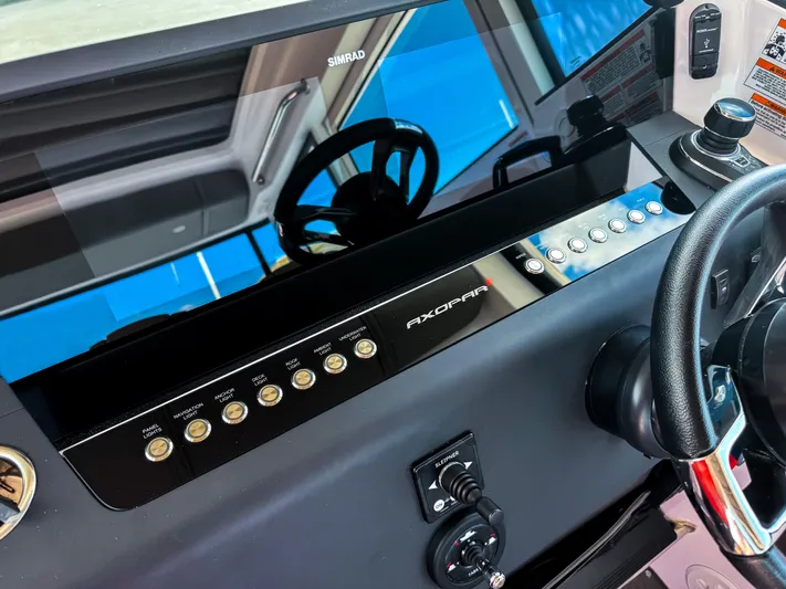  Yacht Photos Pics 2023 Axopar 37 XC CROSS CABIN dashboard with steering wheel and control panel.