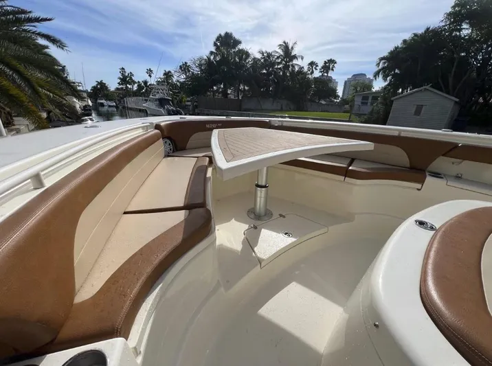 Zooropa Yacht Photos Pics 2016 Scout 420 LXF boat interior with brown seating and a central table.