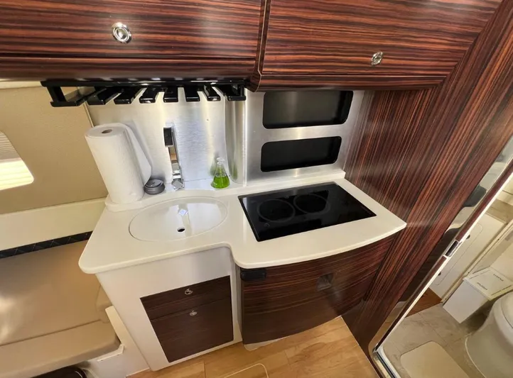 Zooropa Yacht Photos Pics Compact kitchen area in 2016 Scout 420 LXF boat with stove and sink.