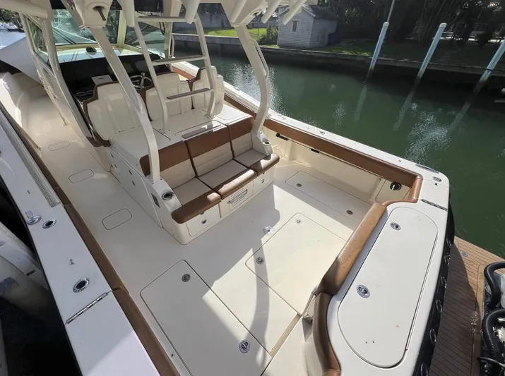 Zooropa Yacht Photos Pics 2016 Scout 420 LXF boat interior with seating and helm, docked by a canal.