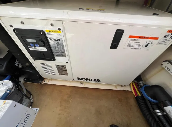 Zooropa Yacht Photos Pics Kohler generator in 2016 Scout 420 LXF boat engine room, showing control panel and warning labels.