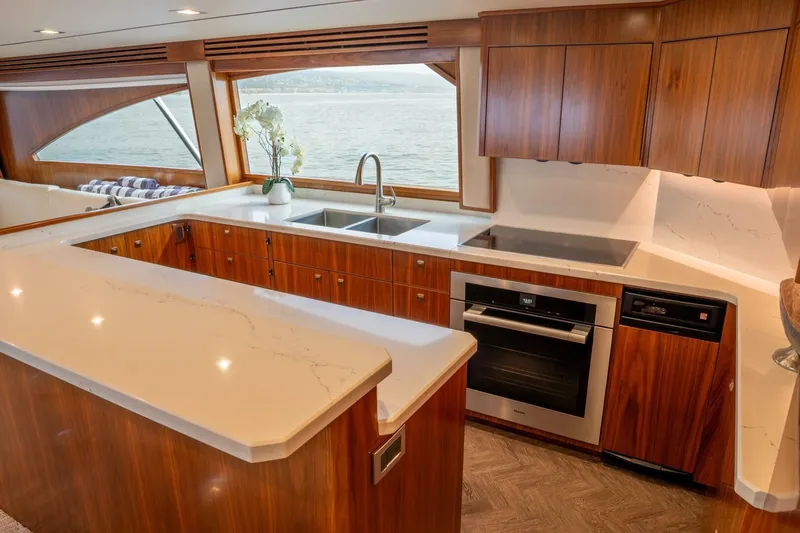 Silvertime Yacht Photos Pics Luxurious kitchen interior of 2018 Viking 80 Enclosed Bridge yacht with wood cabinetry.