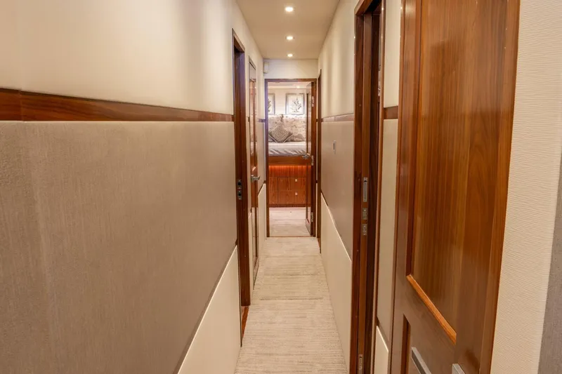 Silvertime Yacht Photos Pics Hallway inside 2018 Viking 80 Enclosed Bridge yacht with wooden doors and soft lighting.