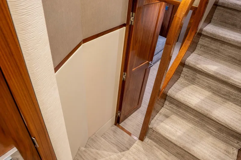 Silvertime Yacht Photos Pics Interior of 2018 Viking 80 Enclosed Bridge yacht, featuring wooden door and carpeted stairs.