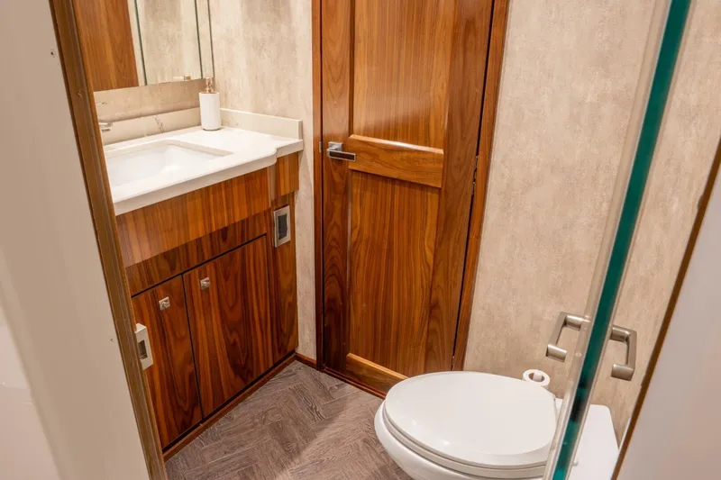 Silvertime Yacht Photos Pics Luxurious bathroom in 2018 Viking 80 Enclosed Bridge yacht with wood accents and modern fixtures.