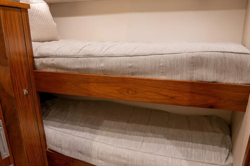 Silvertime Yacht Photos Pics Bunk beds in 2018 Viking 80 Enclosed Bridge yacht cabin, featuring wooden accents and cozy bedding.