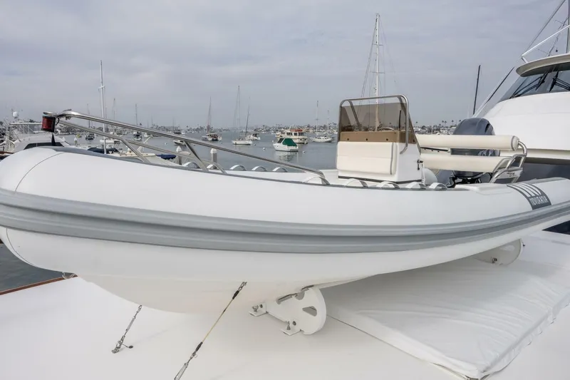 Silvertime Yacht Photos Pics White inflatable boat on a 2018 Viking 80 Enclosed Bridge yacht, docked in a marina.