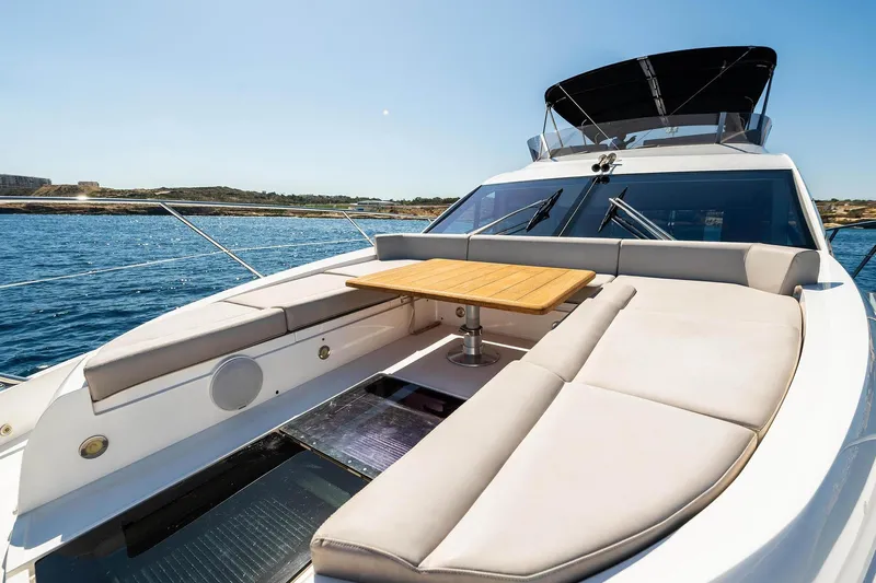  Yacht Photos Pics 2020 Sunseeker Manhattan 52 yacht with luxurious deck seating and table, cruising on open water.