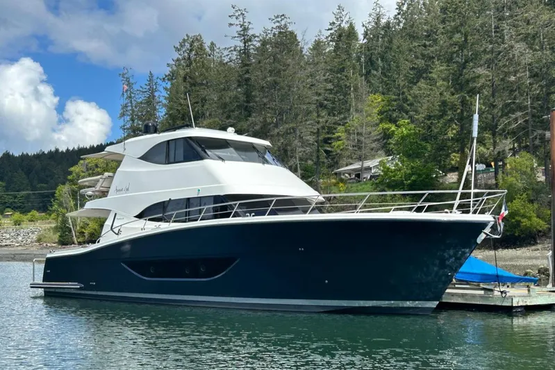  Yacht Photos Pics 2020 Maritimo M64 yacht docked in a scenic marina with forested background.