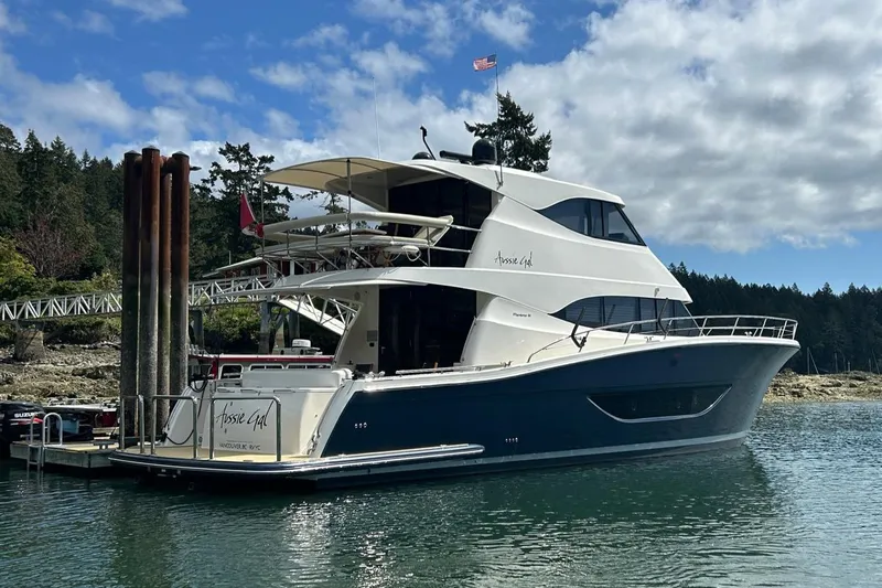  Yacht Photos Pics 2020 Maritimo M64 yacht docked in scenic marina with trees and cloudy sky.