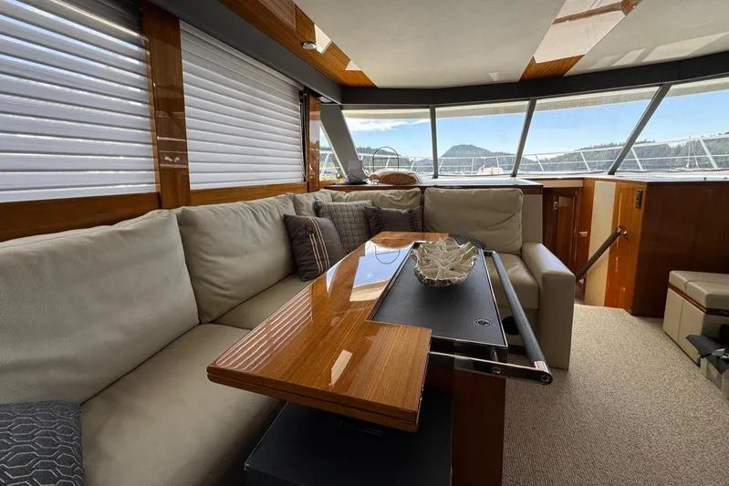  Yacht Photos Pics Luxurious interior of 2020 Maritimo M64 yacht with plush seating and elegant wooden table.