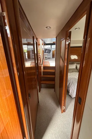  Yacht Photos Pics Interior hallway of 2020 Maritimo M64 yacht with wooden finishes and bedroom view.
