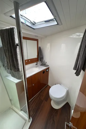  Yacht Photos Pics 2020 Maritimo M64 yacht bathroom with skylight, wooden cabinetry, and modern fixtures.