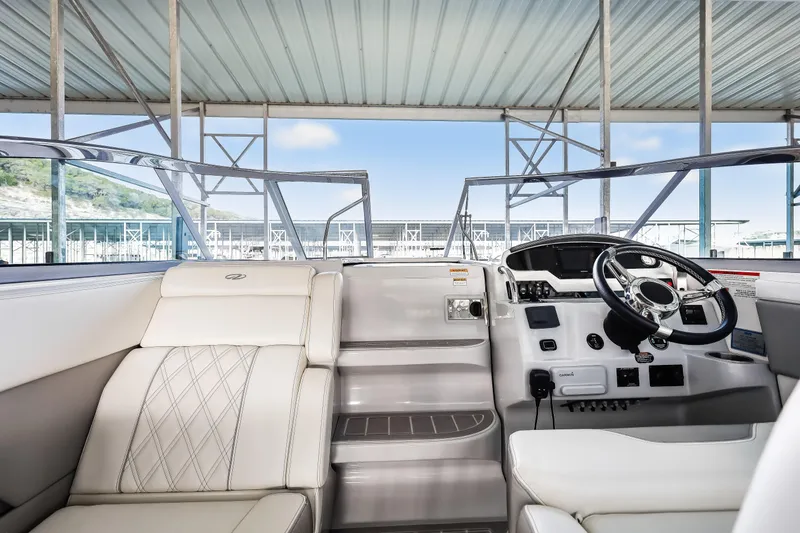 Tarini Yacht Photos Pics 2020 Regal 28 Express boat interior with steering wheel and seating under a covered dock.