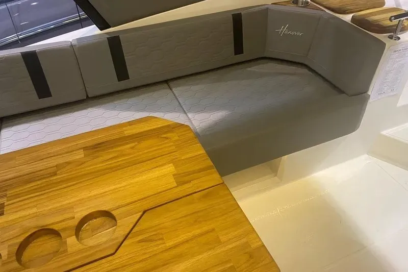  Yacht Photos Pics Luxurious seating and wooden table in 2026 Hanover 387 Tuxedo Luxury Edition boat interior.