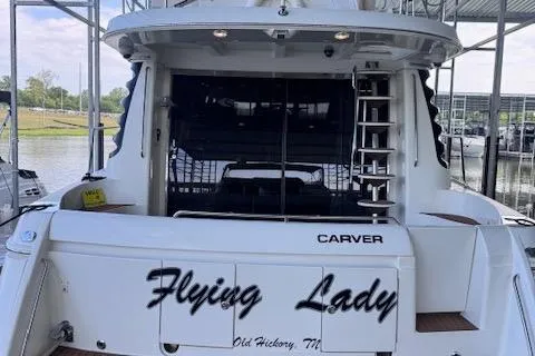 Flying Lady Yacht Photos Pics 2004 Carver 570 Voyager Pilothouse yacht docked, named "Flying Lady," with visible ladder and marina background.