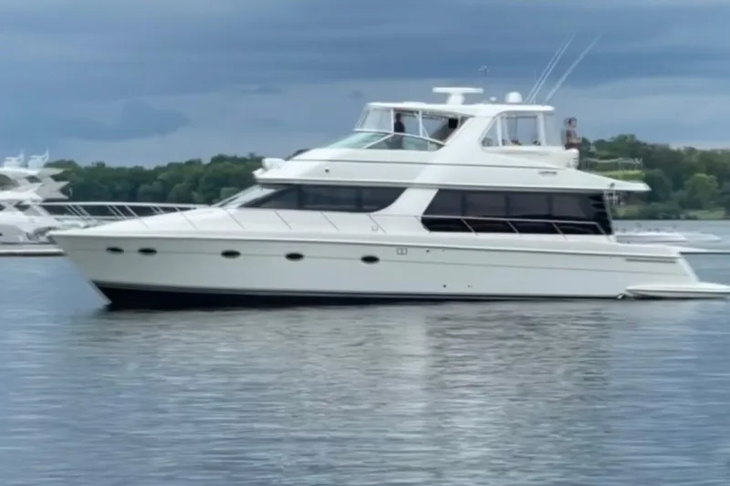 Flying Lady Yacht Photos Pics 2004 Carver 570 Voyager Pilothouse yacht on calm water under cloudy sky.
