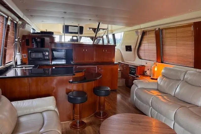 Flying Lady Yacht Photos Pics Luxurious interior of 2004 Carver 570 Voyager Pilothouse with leather seating and modern kitchen.
