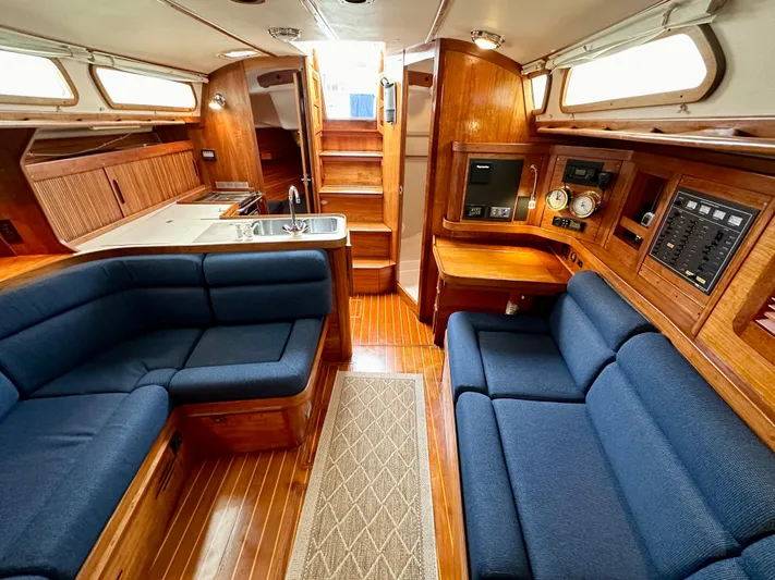 Buena Vida Yacht Photos Pics Interior of 1998 Sabre 362 yacht with blue seating, wooden cabinetry, and navigation instruments.