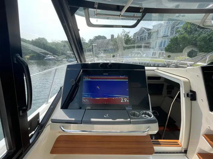 Sea Cure Yacht Photos Pics 2021 Boston Whaler 405 Conquest helm with navigation display, docked near waterfront homes.