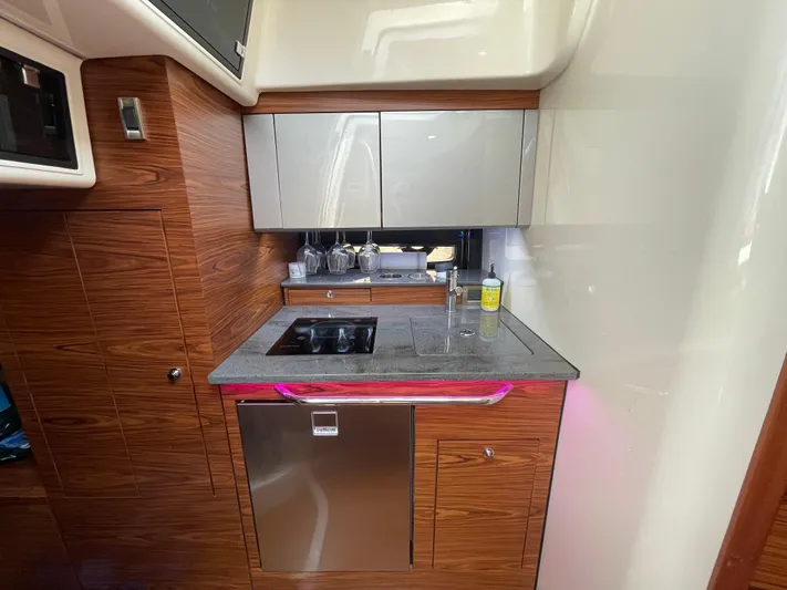Sea Cure Yacht Photos Pics Modern kitchen area in 2021 Boston Whaler 405 Conquest yacht, featuring sleek cabinetry and appliances.