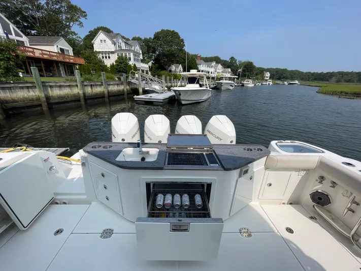Sea Cure Yacht Photos Pics Boston Whaler 405 Conquest 2021 with outdoor kitchen, docked in scenic waterfront setting.
