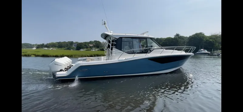 Sea Cure Yacht Photos Pics 2021 Boston Whaler 405 Conquest cruising on a calm river with scenic greenery.