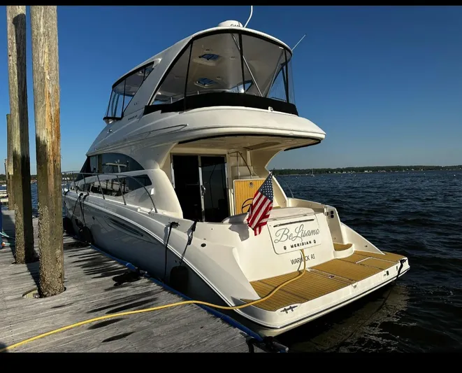  Yacht Photos Pics 2009 Meridian 441 Sedan yacht docked, rear view with American flag, clear blue sky.