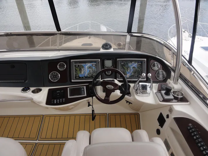  Yacht Photos Pics 2009 Meridian 441 Sedan helm with navigation screens and controls, docked by the water.